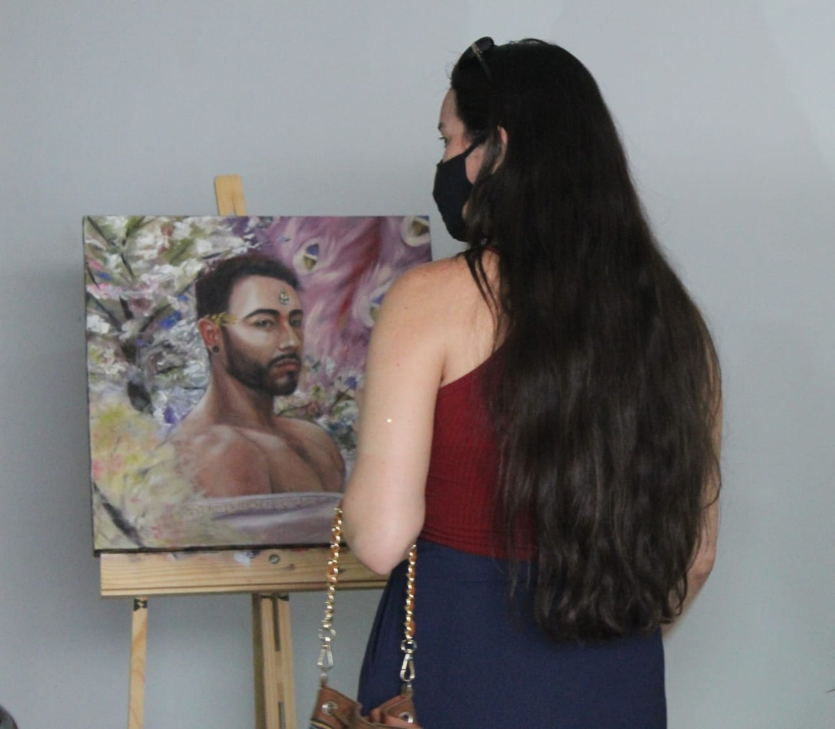 A guest viewing a male portrait on an easel at the 2021 exhibition
