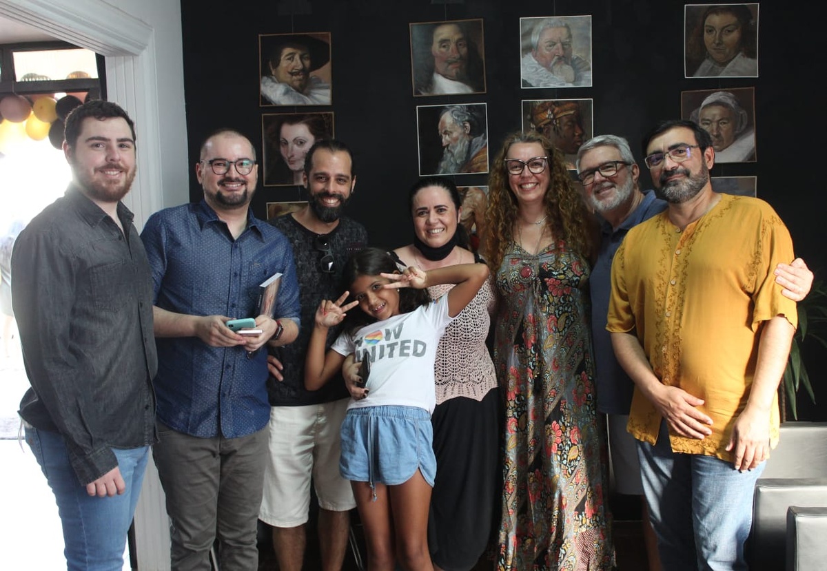 Régis Souto with guests in front of the wall of classical portrait studies at the 2021 launch in Santa Bárbara d'Oeste